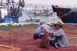 Image du Maroc Professionnelle de  Quelques ouvriers s'activent à réparer les filets de pêche sur un des quais au port d'Agadir, ville située au sud du Maroc, Vendredi 23 Août 2002. (Photo / Abdeljalil Bounhar)

 